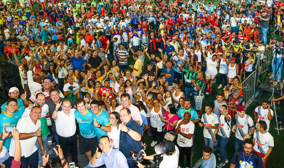 a fotos mostra centenas de pessoas posando para a foto num campo de futebol